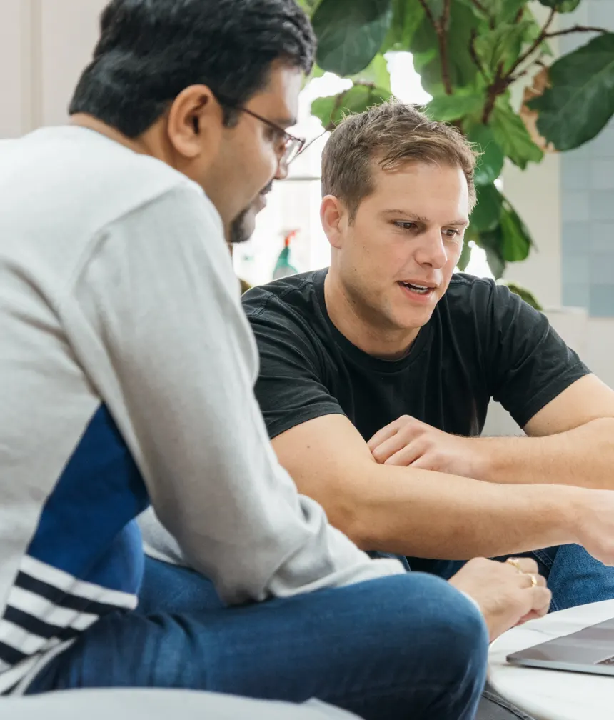 Two Lookahead engineers reviewing code together on a laptop
